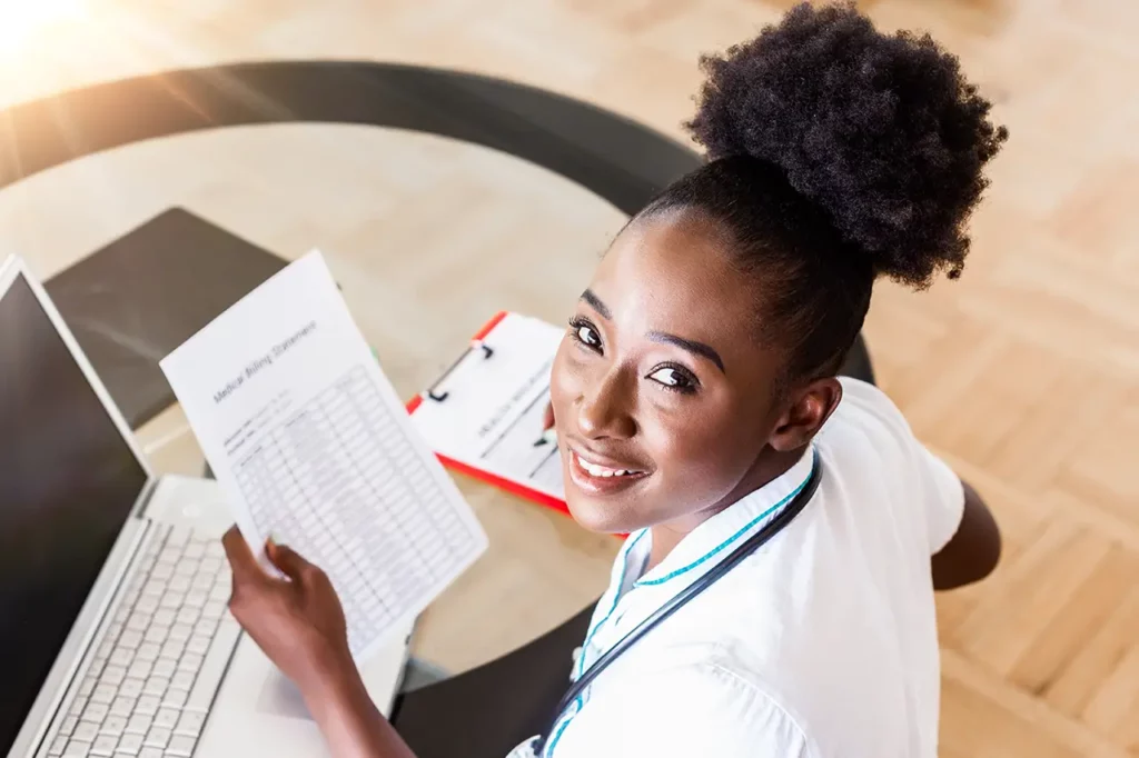 Medical Biller beautiful you african american woman at desk posing for camera